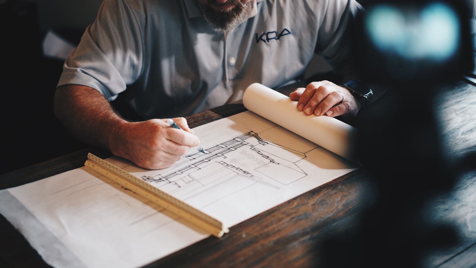 Architectural drawings being reviewed by hand — a detail-led approach to every mandate